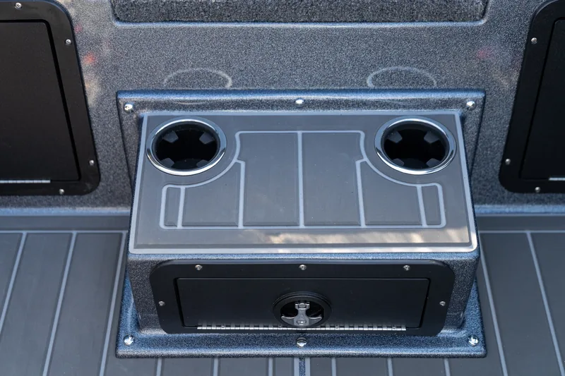 A closed rear storage box with a molded top holding two recessed cup holders on the cockpit deck.