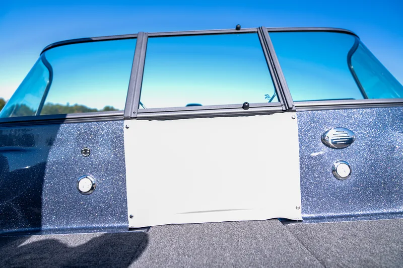 The closed center windshield panel viewed from the bow deck under a clear blue sky.