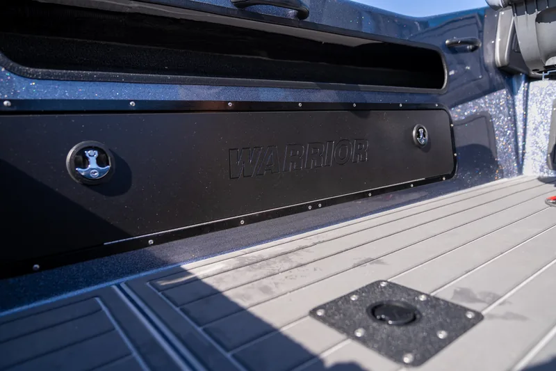 A long closed side rod locker door with the Warrior logo embossed, alongside the cockpit floor.