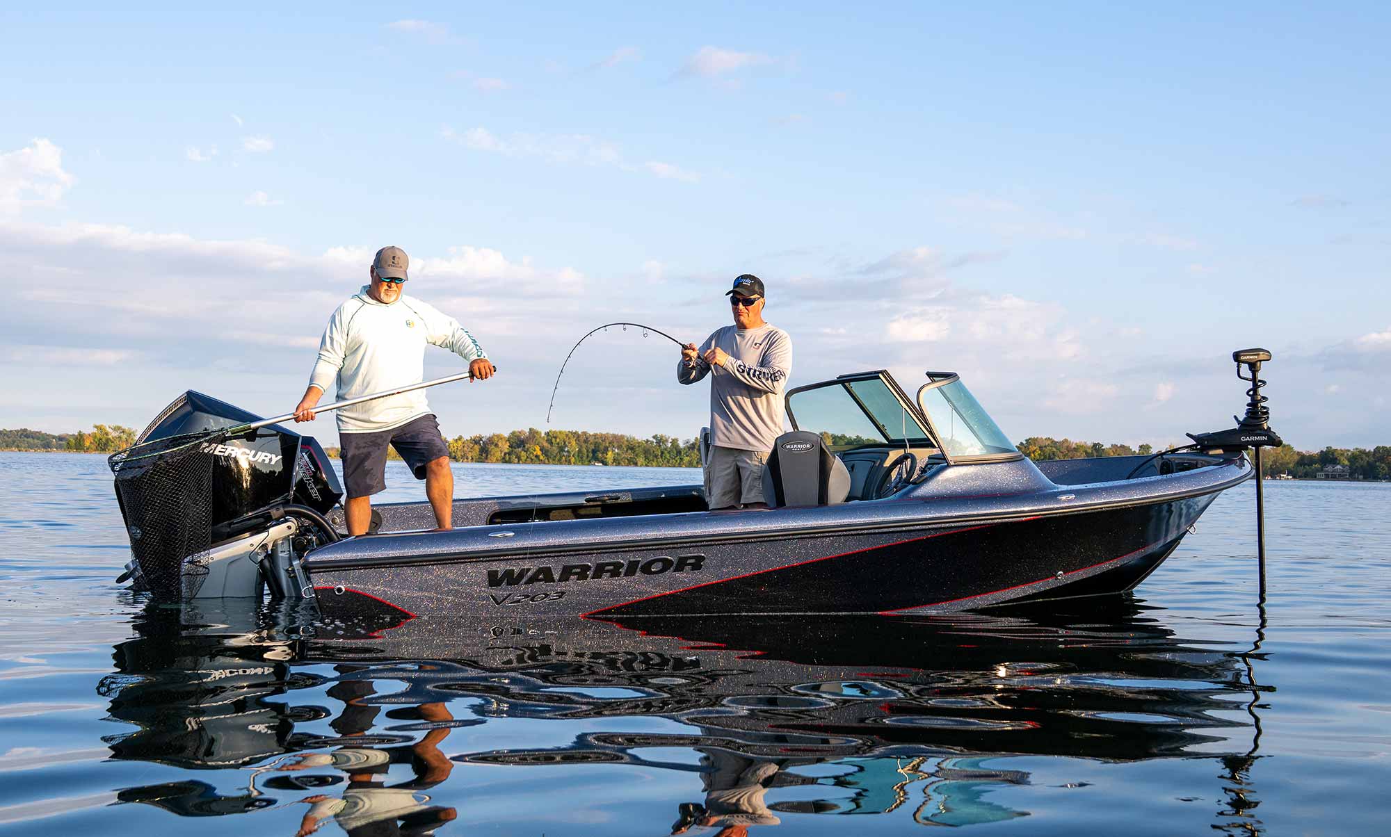 Two anglers landing a fish from a Warrior V203